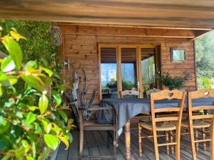 - une table et des chaises sur une terrasse couverte avec une table et un miroir dans l'établissement L'ALIVETU, Chambres d'hôtes, à Bastelicaccia