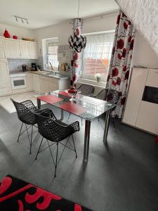 グレートジールにあるFerienwohnung Sonnenkieker Greetsielのガラスのテーブルと椅子付きのキッチン