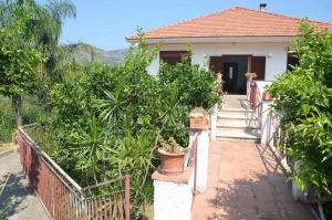 a house with a walkway leading to the front door at Gole dell'Alcantara Villa Lucia II in Motta Camastra