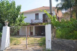 une clôture devant une maison blanche dans l'établissement Gole dell'Alcantara Villa Lucia II, à Motta Camastra