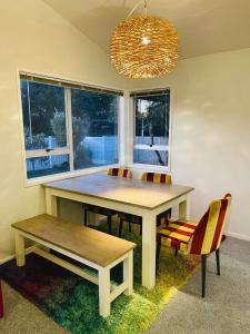 a dining room table with a bench and a chandelier at Aucktons house in Auckland