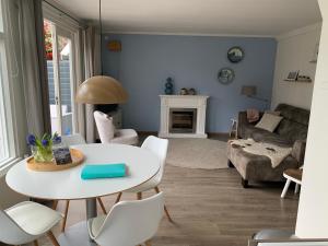 sala de estar con mesa blanca y sillas en Appelbloesem, en Bergen