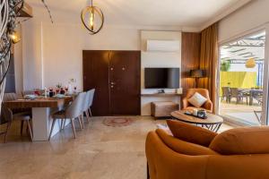 Villa Marine Luxury في كاس: غرفة معيشة مع طاولة وغرفة طعام