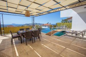 un patio con mesa, sillas y piscina en Villa Marine Luxury en Kas
