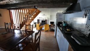 eine Küche mit einer Theke und einer Treppe in einem Zimmer in der Unterkunft Le Hameau du Pagnon in Saint-Mesmin