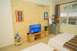 a room with a television on a brick wall at Jasmine Hotel in Ho Chi Minh City