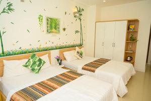 two beds in a room with flowers on the wall at Jasmine Hotel in Ho Chi Minh City