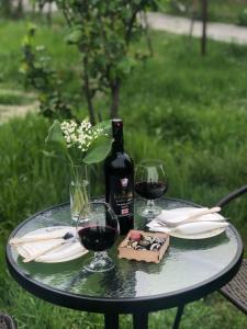 a table with a bottle of wine and two glasses at Cozy House in Tʼelavi