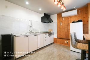 uma cozinha com armários brancos e um frigorífico branco em Culture24 em Sapporo