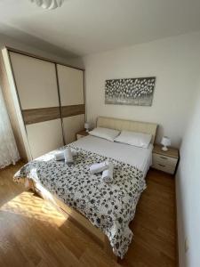 una camera da letto con un letto con un piumone bianco e nero di City Apartment Nature a Kaštela (Castelli)