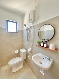 a bathroom with a toilet and a sink and a mirror at NEW Modern Suite near Airport & Beach in Sudtungan