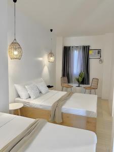1 dormitorio con 2 camas, 2 sillas y 2 luces en NEW Modern Suite near Airport & Beach, en Sudtungan
