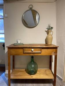 a wooden table with a vase and a mirror at Can Moletes in Pratdip