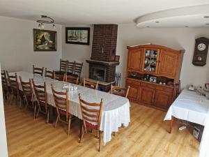 a dining room with a table and chairs and a fireplace at Agrostrzecha in Ryczów