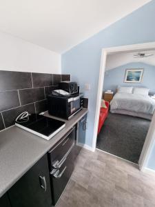 a kitchen with a microwave and a bed in a room at The Garden Suite Holt in Holt