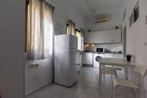a white kitchen with a table and a refrigerator at Piso Reformado in Vecindario