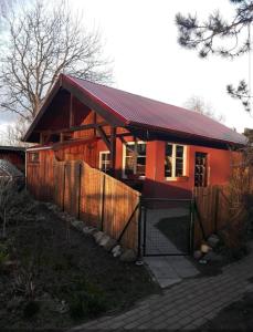 a small orange house with a fence in front of it at Haus Abendsonne in Barth