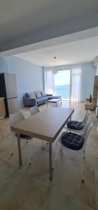 a living room with a table and a couch at Summer Breeze Apartment Saranda in Sarandë
