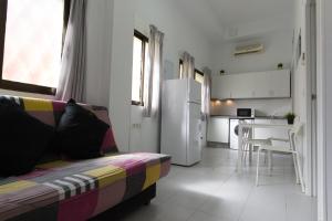 a living room with a couch and a kitchen at Piso Reformado in Vecindario +7 photos
