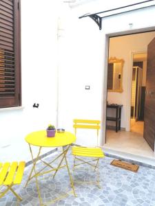 un tavolo giallo e 2 sedie su un patio di Casa B&Bike Da Marina bike-friendly a Taranto