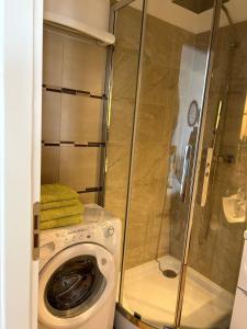 a bathroom with a washing machine and a shower at La Couronne Appartement a Nice in Nice