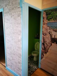 a bathroom with a toilet and a stone wall at Guingamp centre : grand appartement lumineux in Guingamp