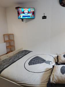 a bedroom with a bed and a tv on the wall at House of twenty, calme,rue piétonne, proche de la mer, wifi gratuit in Dieppe