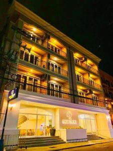 a large building with a balcony on a street at night at Ivory Palace Hotel in Pattaya Central