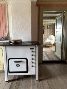 a stove sitting on a wooden floor in a room at Husmannsplassen Havrebakken på Helgøya in Ringsaker