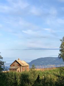 uma casa velha sentada em cima de um campo em Husmannsplassen Havrebakken på Helgøya em Ringsaker