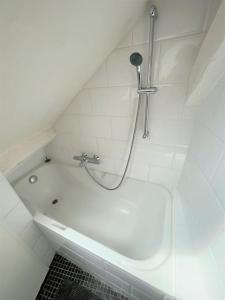 y baño con bañera blanca y ducha. en Le Bohème - Centre de Paris - Belle vue - Wifi en París