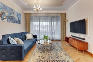 a living room with a blue couch and a tv at Granaria by Welcome Apartment in Gdańsk