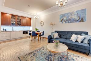 a living room with a blue couch and a table at Granaria by Welcome Apartment in Gdańsk