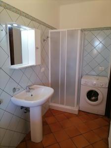 ein Badezimmer mit einem Waschbecken und einer Waschmaschine in der Unterkunft Appartamento Liam in Marzamemi