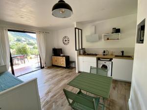 sala de estar con mesa y cocina en Les Marines, Castello Rosso vue mer - Accès plage à pied, en Casaglione