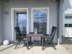 een tafel met 2 stoelen en een lantaarn op een patio bij Apartment „Am Südhang“ in Odelzhausen