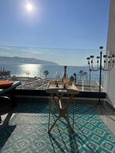um quarto com uma mesa e vista para o oceano em Sunset Resort em Vlorë