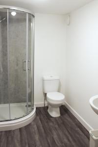 a bathroom with a toilet and a glass shower at Comfy Studio with Transport Links to MCR in Heywood