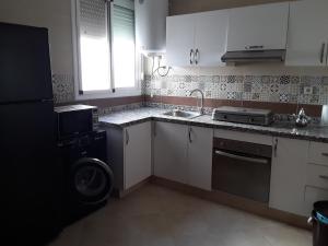 a kitchen with a washer and a sink and a dishwasher at Fathia1 Gerant Maison d hote in Saïdia