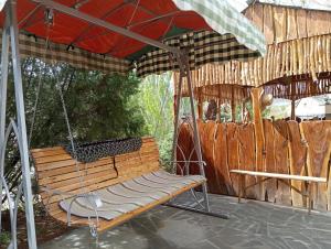 a swinging chair under an umbrella on a patio at Luiza Guest House in Areni