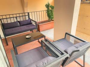 een balkon met 2 stoelen, een tafel en een bank bij Magoria, nel cuore della Città Vecchia di Locarno in Locarno