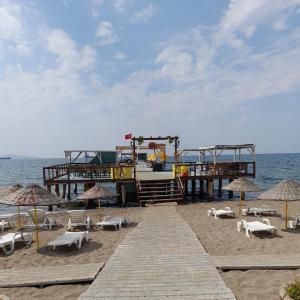 a pier with chairs and umbrellas on the beach at Dikili in Dikili