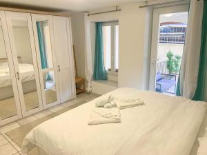 a white bed in a room with a large window at Magoria, nel cuore della Città Vecchia di Locarno in Locarno