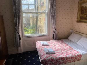 um quarto com uma cama com duas toalhas em Oakley Hotel em Londres