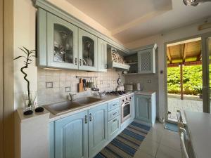 een keuken met blauwe kasten en een wastafel bij Grazy House in Marina di Modica
