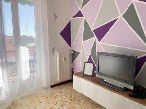 un soggiorno con TV e parete geometrica di Argentina Home a Ventimiglia