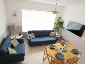 a living room with a blue couch and a table at Private 2 bedroom house close to the beach in Paignton