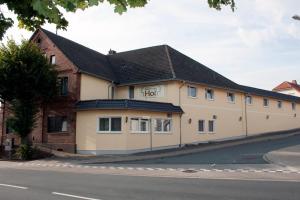 un bâtiment blanc avec un toit noir dans une rue dans l'établissement Gasthaus Bonneberger Hof, à Vlotho