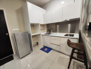 uma cozinha com armários brancos e uma cadeira em Twin Galaxy King Bed 2pax with Netflix nice city view em Johor Bahru
