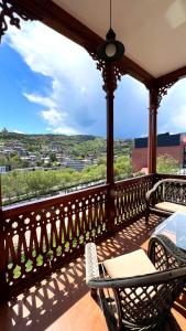 a balcony with chairs and a view of a city at Marmenio Hotel - Tbilisi in Tbilisi City